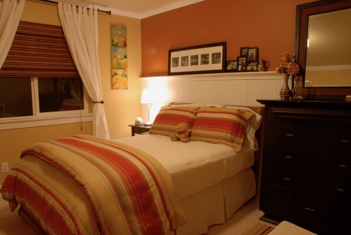 transitional designed bedroom with plate rail / chair rail used in the bedroom to hold photos and mementos in a decorative fashion