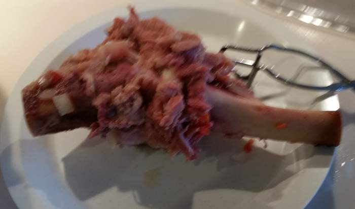 Let it cool, then pull off the bits of meat clinging to the bone. Put the meat back into the soup. Discard the bone.