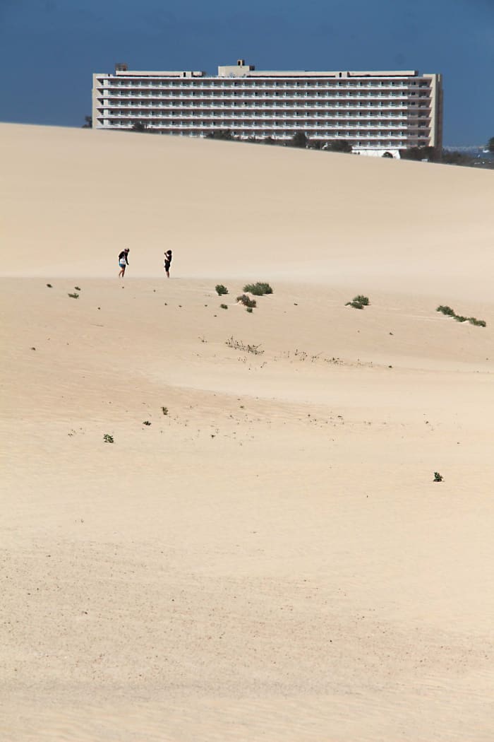The ClubHotel Riu Oliva Beach across the expanse of sand dunes near Corralejo. The extent of these dunes can be guaged by the two figures in the middle distance