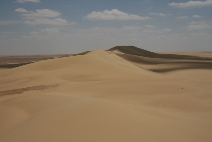 The Qattara Depression the largest in the world. The Qattara Depression lies 436 feet below sea level, and its bottom is covered with salt pans, sand dunes, and salt marshes.