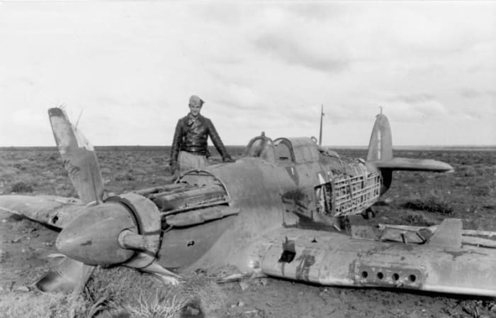Hans-Joachim Marseille standing next to one of his aerial victories, a Hurricane Mk IIB of No. 213 Squadron RAF, February 1942.