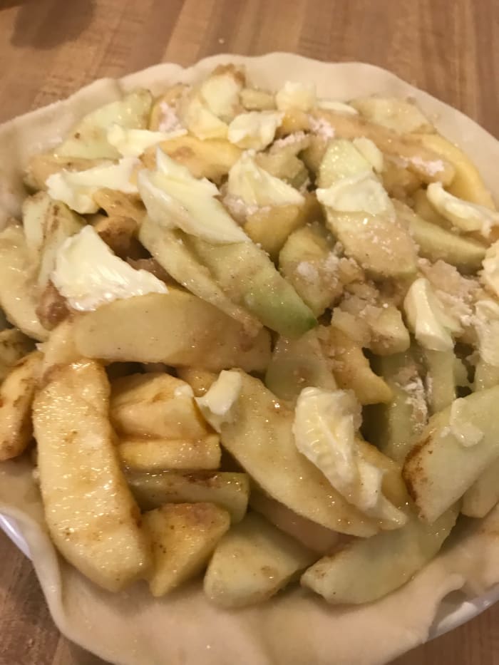 Dot the apples with butter. Line a 9 inch pie dish with pastry, and transfer pies to the dish. Move the apples around so they leave as little air space as possible, then top with a second crust.