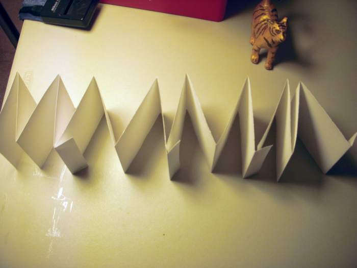 All strips, folded accordian-style, ready to be glued together in one long strip. Notice how the "tabs" are all on the same side.