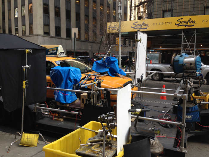 "A New York City taxicab loaded onto a "process trailer" with lights and cameras in preparation for a filming . . . "