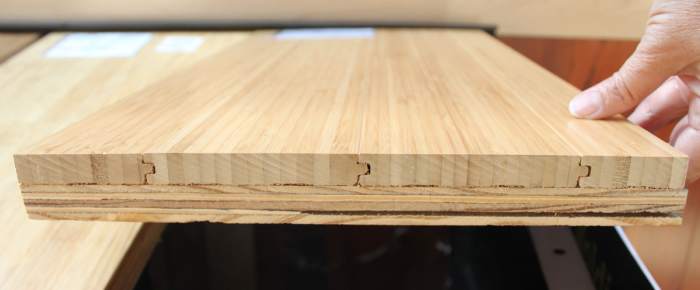 This is the edge of a flooring sample of solid vertical bamboo mounted on a piece of plywood.