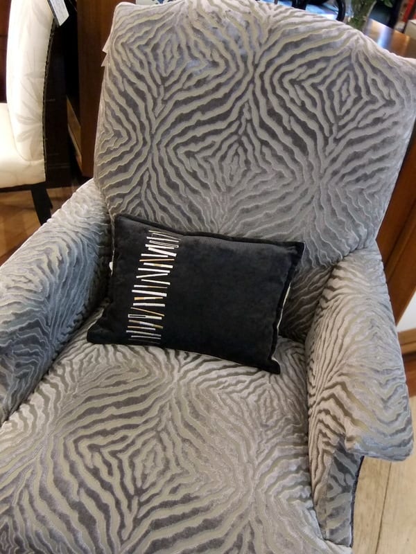 11. A black colored throw cushion with white and gray pattern, to pick up the main color of the armchair