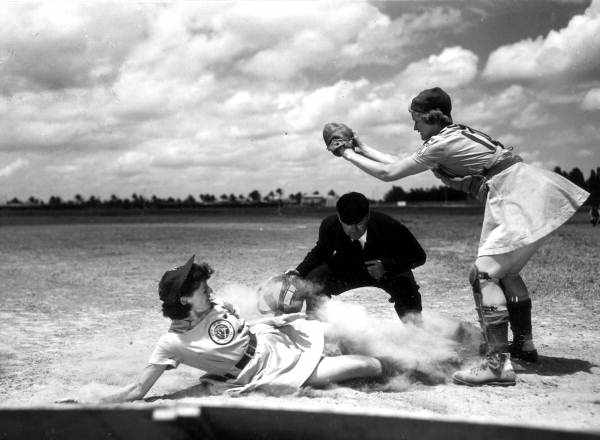 Members of the All-American Girls Professional Baseball League (AAGPBL) play it rough in a male sport. A 1948 shot of player Marge Callaghan sliding into home plate.