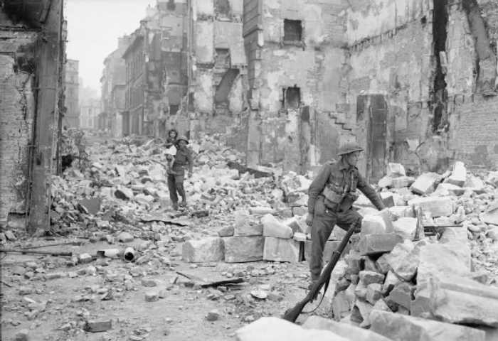 A British soldier rescues a French girl in a ruined city, WW2, summer 1944.