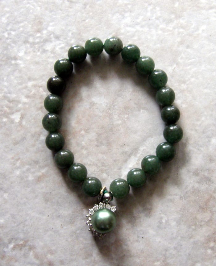 Jade bracelet with enhanced green pearl, surrounded by cubic zirconias. Many cultures, including the Irish, see the color green as a symbol of good luck.