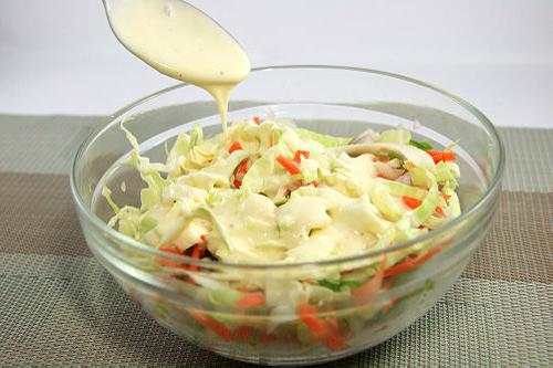 Use a large spoon and mix your cole slaw dressing into the slaw, carrots, peppers and onions and stir well.