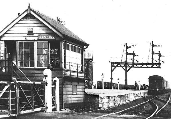 Seghill Station signal cabin controls the crossing gates as well as the signals - interesting bracket formation at the far end of the platform