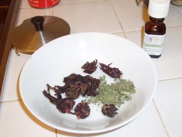 Choose herbs and essential oils. Pictured here are rose hips, mint leaves, and eucalyptus oil (in the little bottle).
