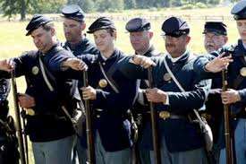 Members of the 20th Maine Volunteers Living History Association "Charge Cartridges" (place the cartridges, powder-side down, into the muzzles of the muskets)