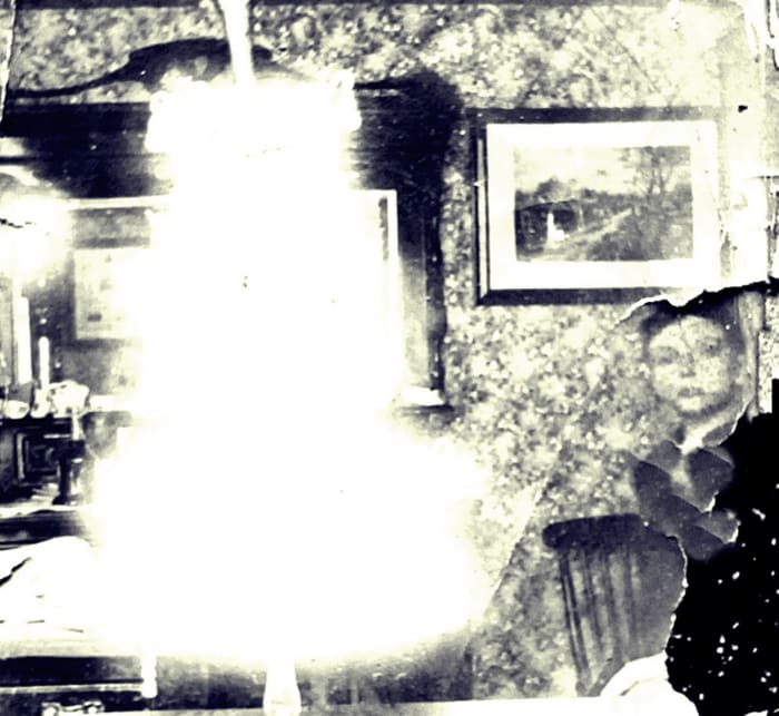 An early photo of my grandad, just visible on the right, with a wedding cake. It would have been the wedding of one of his older siblings.