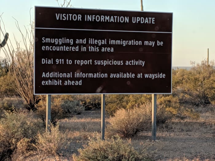 Sign warning about possible smuggling and illegal immigration taking place in area.. Sign further down road recommends being alert and not going off designated trails for hiking to avoid encounters.