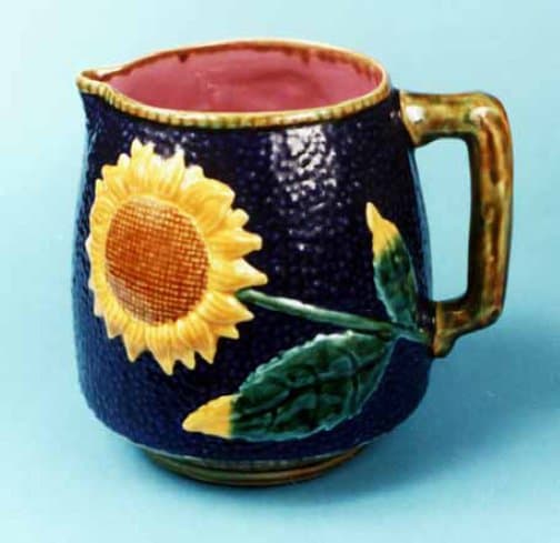 The photo depicts a Sunflower pattern pitcher. The mold for this pitcher was taken directly from an old original.Majolica pitcher. The mark of the original pitcher's maker can, Etruscan Majolica, appears on the bottom of this reproduction.