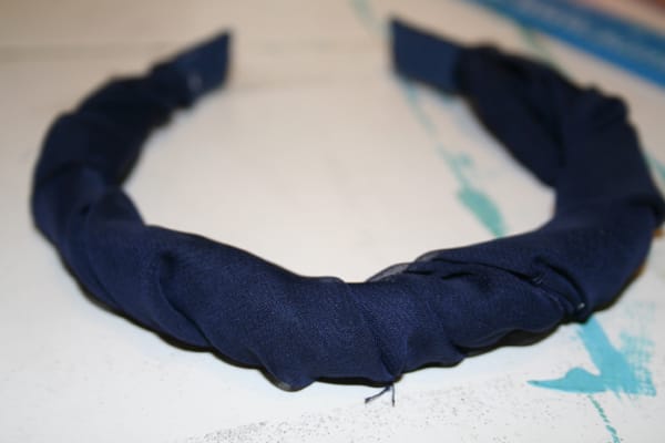 I wound up twisting it around the headband and then gluing it at each end. Then, I took my needle and thread and stitched together the materials to give it a more uniform look.