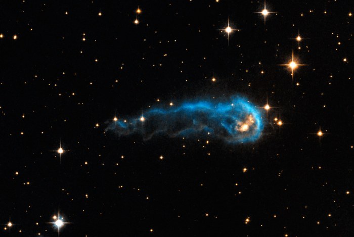 This light-year-long knot of interstellar gas and dust resembles a massive caterpillar. Harsh winds from extremely bright stars are blasting ultraviolet radiation at this "wanna-be" star and sculpting the gas and dust into its long shape. The culprit