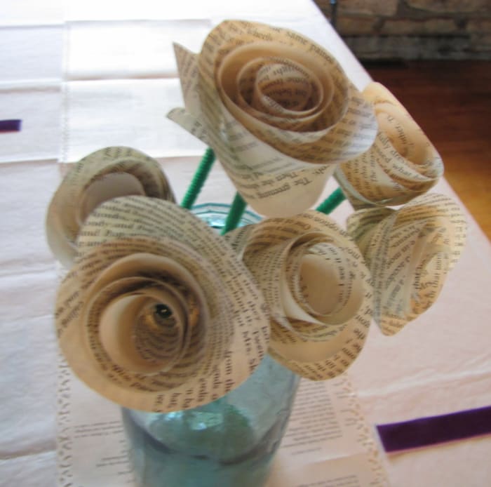 My niece, a librarian, had a book themed wedding, since she is a librarian. The runners down the center of the tables were book pages with artful edges (scrapbooking technique) and she made roses from book pages for centerpieces.