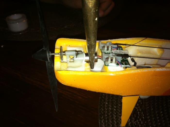 After cutting the foamy glue, use a pair of needle nose pliers to GENTLY pull the motor from the housing.