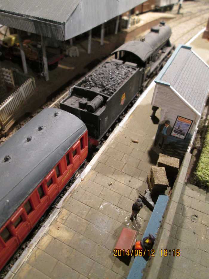 A look down on the platform towards the open fronted platform shelter (Hornby Skaledale range) beside D49/2 62764, 'The Garth' with her train of 1920s Gresley passenger stock. 'Brown boxes' by same platform shelter are pigeon baskets for forwarding