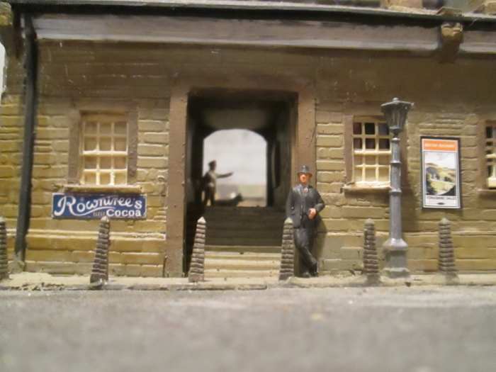 The view straight on from across the road into the entrance. Don't know if he's waiting for someone - looks a bit shady if you ask me - maybe a spiv with black market goods to flog (slang for 'sell').