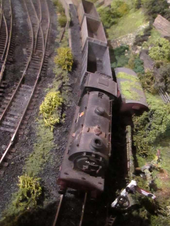 (Hornby) J94 68010 holds empty Loco Coal wagons at the short starter post, awaiting the right away.