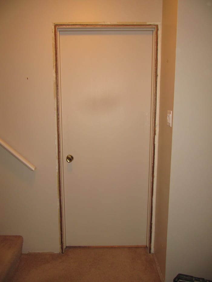 Old door waiting to be ripped out. Cut the door out by using a reciprocating saw and cutting between the jamb and the framing.
