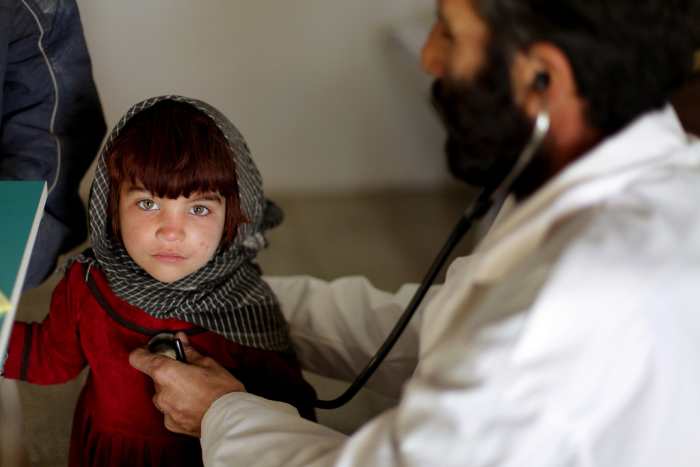 An Afghan physician listens to an Afghan girl's heart at a clinic on Camp Clark, Khowst province, Afghanistan.