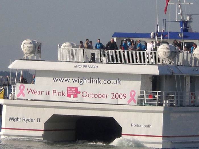 The whole world benefits from public awareness and support for breast cancer prevention, treatment, and cure. This is the stern of the Wightlinks Wight Ryder II and a poster for breast cancer awareness, October 2009