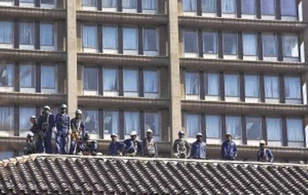 Construction workers watch strikers march through Johannesburg. Economists are warning of a global double-dip recession and say unions aren't helping SA lure foreign investment