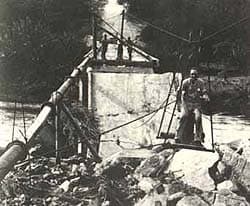 At a later stage of the operation a slightly more sophisticated type of bosun's chair takes Mr. Karel Kolkenbeck-Ruh across when the Selati River is in full flood