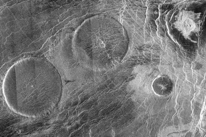 A group of pancake domes called the Carmenta Farra. The largest of these domes is 65 km (40 miles) across and about 1000 m (3200 ft) high. Top right in this photograph is a 12 km (7.5 mile) diameter impact crater known as Margareta