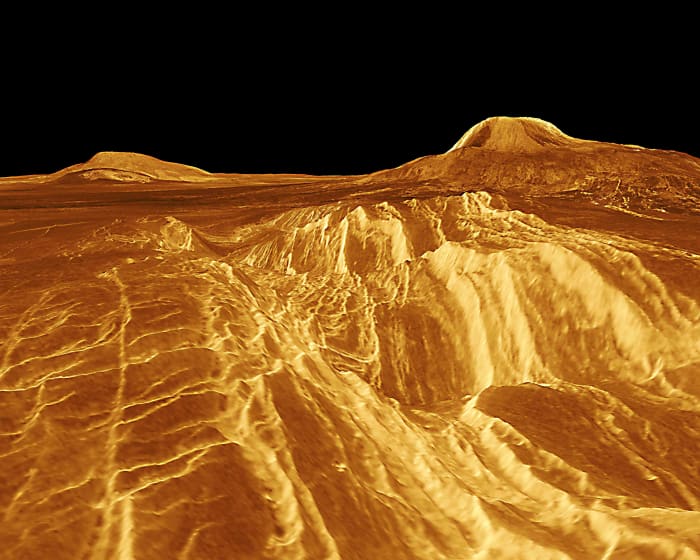 Two great shield volcanoes in Western Eistla Regio. Sif Mons (on the left) rises 2 km (1.2 miles) above the plain, and Gula Mons (on the right) is 3 km (1.8 miles) high.The distance between Sif Mons and Gula Mons is about 730 km (450 miles).