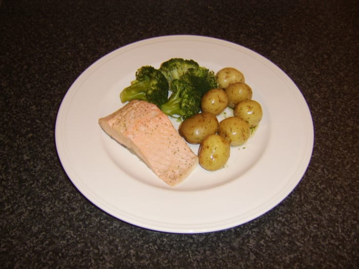 Scottish salmon loin fillet, poached in white wine and served with herb buttered new potatoes and broccoli