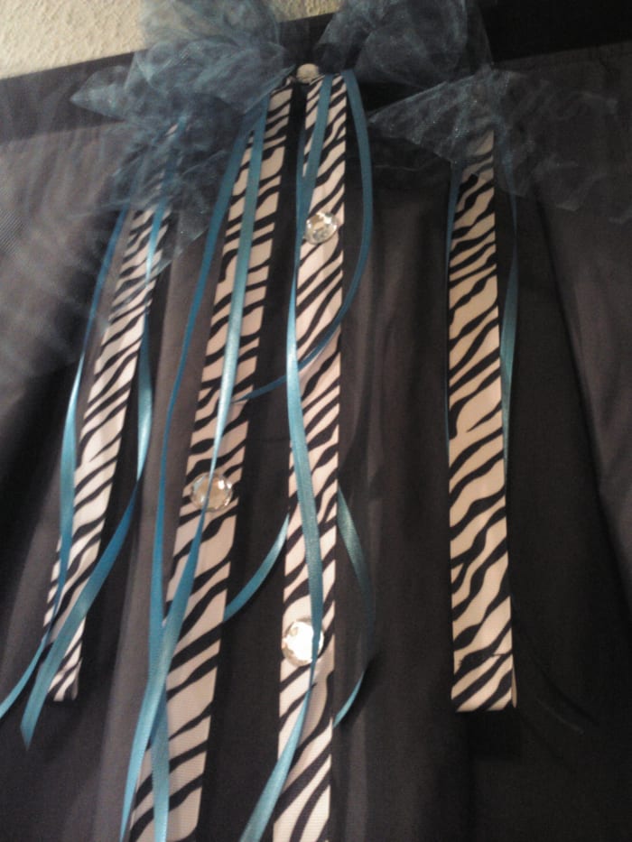 The addition of zebra ribbon, blue netting and rhinestones makes the changing room shine! A chair, rug and mirror make it functional! All in all a great alternative for outdoor events!