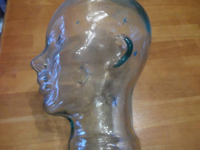 Glass face bust displaying areas wires are attached to a patient's head during a sleep study.
