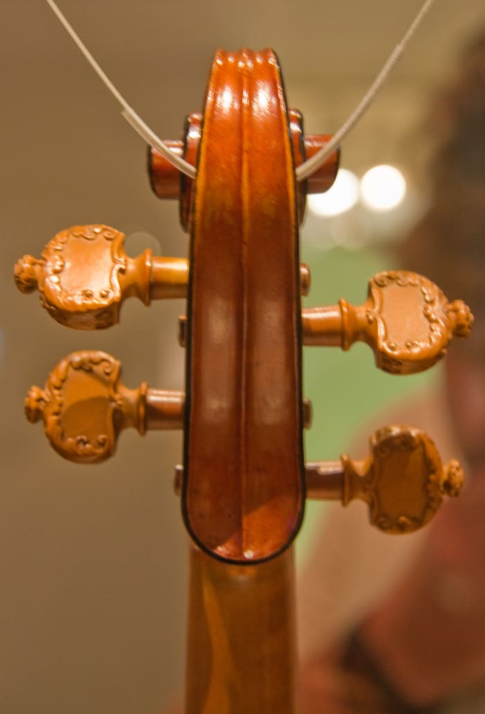 Scroll of the Messiah Stradivarius from the back, showing the black edging almost completely intact and the carved pegs added by J.B. Viullaume