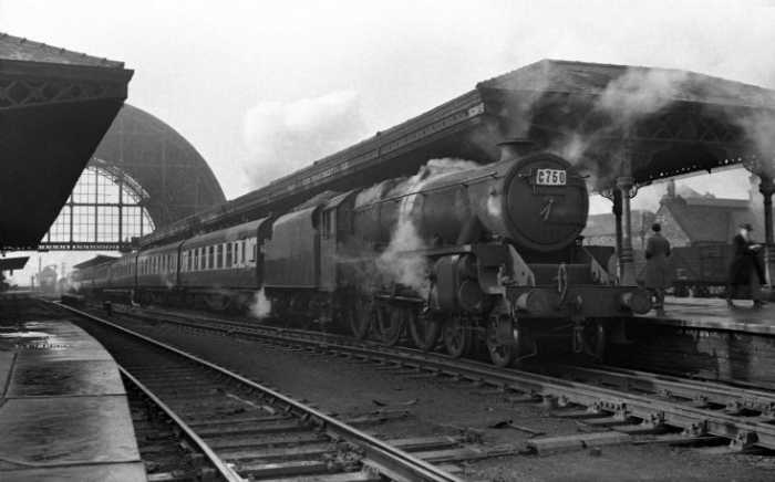 Race Special from BR Midland Region behind an unidentifiable 'Black Five' (Class 5 4-6-0) stands at Middlesbrough Station pre-1954 (remainder of overall roof still in situ)