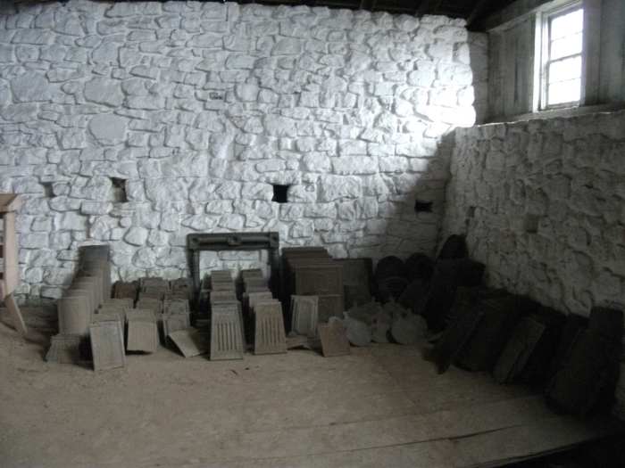 Iron stove parts stacked in the casting house of Hopewell Furnace.