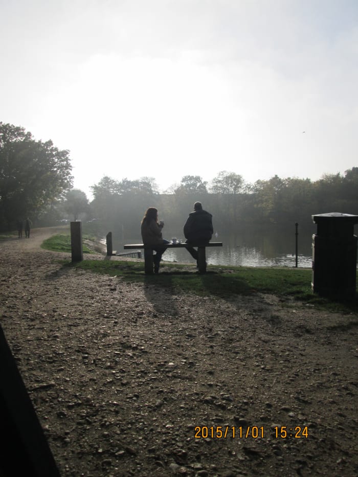 Autumn is well and truly in the air at around four in this Sunday afternoon shot. A conversation takes place on the lakeside bench ahead
