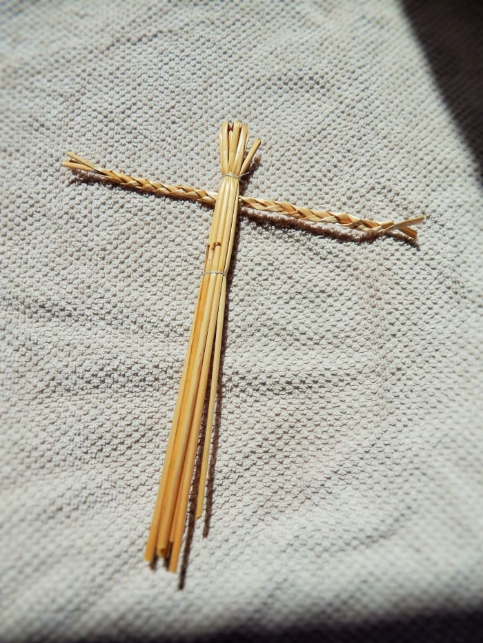 Fig. 4. Feed the arm piece of your Straw Man through the body, then tie the bottom of the body tightly with string to make secure.