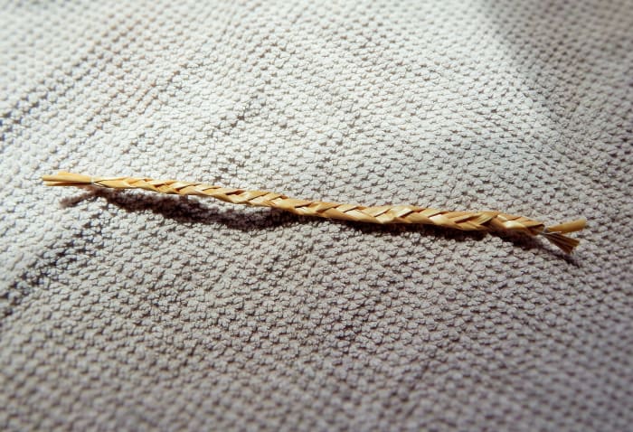Fig. 3. Take 3 pieces of straw of equal length for the arms of your Straw Man. Plait or simply tie on each end.