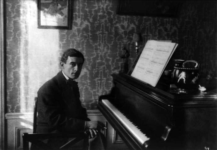 Maurice Ravel seated at the piano in 1912.