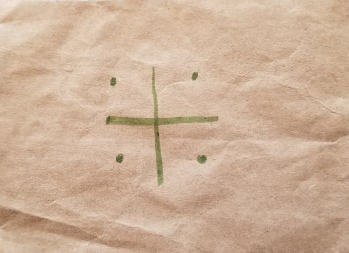 Step 1: Draw a plus sign with four dots at the corners. This process is pictured with separage squares cut from a paper bag, but is meant for you to coplete on the same piece of paper.