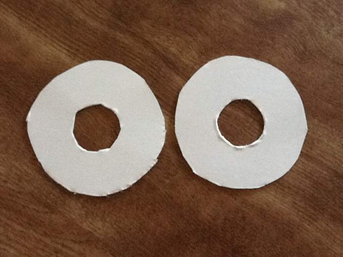 Cut out 2 circles from cardboard. Cut 2 circles from center to make a doughnut. The size of the circle will depend on how big a pom pom you want. I used a drinking glass for thew outside circle, for the inside I used a bottle cap.