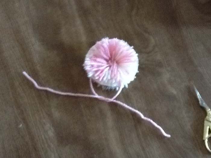 Take another piece of yarn and gently place between the two pieces of cardboard. Pull tight. Tie.
