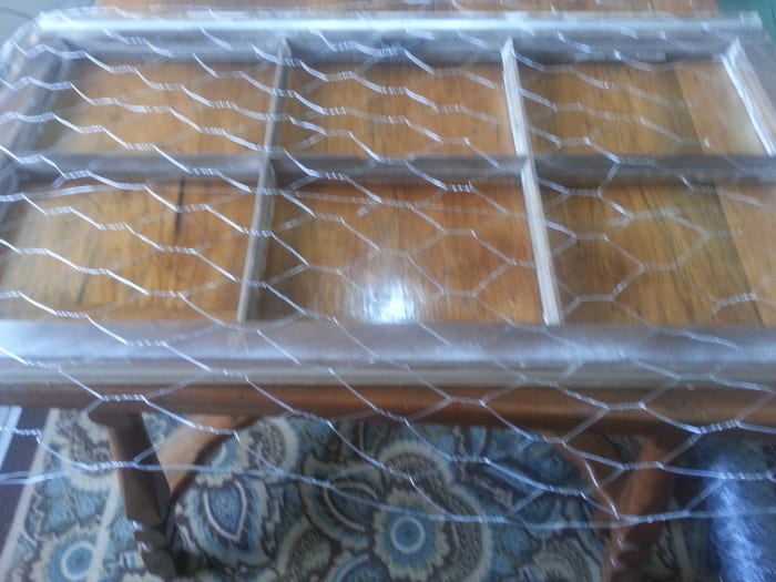 Stapling chicken wire on back of old wood window without glass to make a message / picture board.