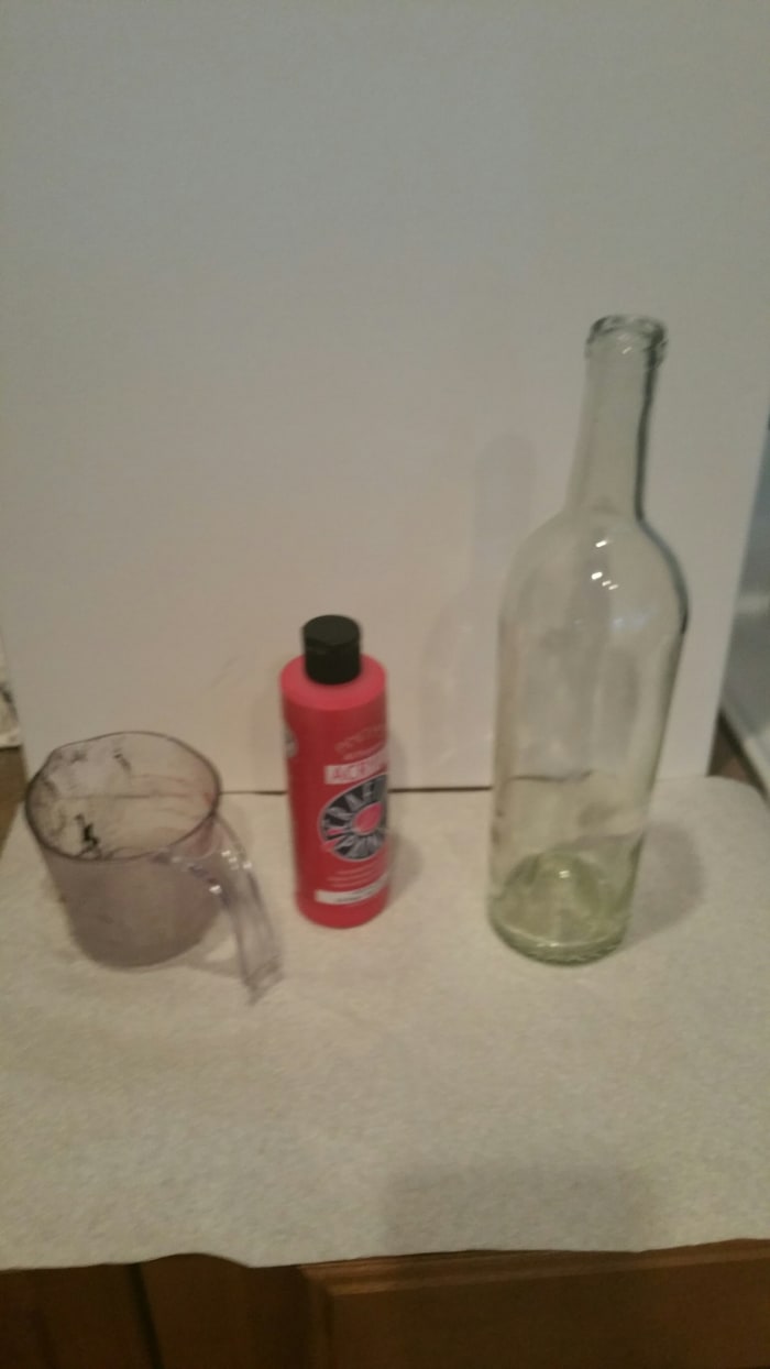 You'll need a wine bottle with the labels removed, some paint (I used acrylic), and an old measuring cup or something you can easily pour from.