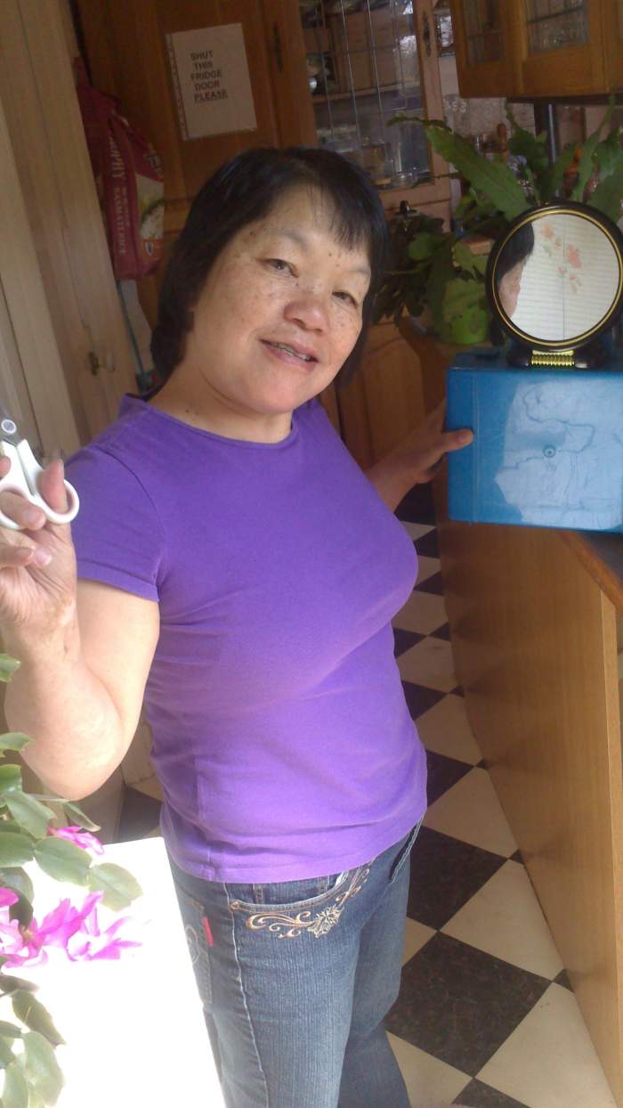 This is me with the small mirror for use to see the back of my head. The big mirror is behind me on the wall.